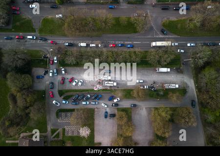 Clapgate Lane, Birmingham, 4. April 2025: Die Bewohner haben sich so weit das Auge reicht, um ihren Müll am Freitagmorgen an einer vorübergehenden Müllsammelstelle abzugeben. Die Fahrzeuge waren Stoßfänger an Stoßfänger entlang der Clapgate Lane, die bis zum Woodgate Valley Country Park, einem Naturschutzgebiet, führten, wo sie ihre Müllsäcke in einen Müllwagen kippten. Die Szenen waren besser organisiert als in den vergangenen Tagen, obwohl der Verkehr viele Menschen um eine Stunde auf Reisen brachte. Der Stadtrat von Birmingham hat die Stadt in einen großen Vorfall versetzt, um den Rückstand der Abfälle zu beseitigen, nachdem Müllarbeiter dies getan haben Stockfoto