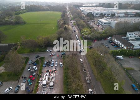 Clapgate Lane, Birmingham, 4. April 2025: Die Bewohner haben sich so weit das Auge reicht, um ihren Müll am Freitagmorgen an einer vorübergehenden Müllsammelstelle abzugeben. Die Fahrzeuge waren Stoßfänger an Stoßfänger entlang der Clapgate Lane, die bis zum Woodgate Valley Country Park, einem Naturschutzgebiet, führten, wo sie ihre Müllsäcke in einen Müllwagen kippten. Die Szenen waren besser organisiert als in den vergangenen Tagen, obwohl der Verkehr viele Menschen um eine Stunde auf Reisen brachte. Der Stadtrat von Birmingham hat die Stadt in einen großen Vorfall versetzt, um den Rückstand der Abfälle zu beseitigen, nachdem Müllarbeiter dies getan haben Stockfoto