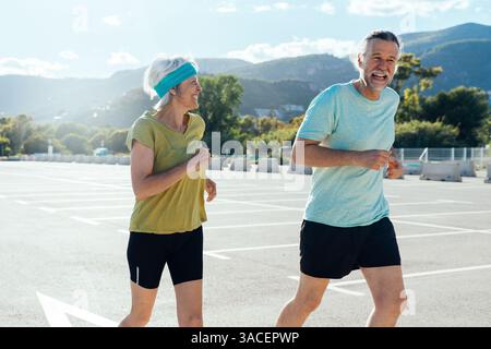 Wunderschönes glückliches Seniorenpaar, das draußen läuft - reifes verheiratetes Paar, das verliebt ist, sich draußen zu verbinden und gemeinsam Sport zu treiben, Konzepte über ältere Menschen Stockfoto