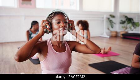 Kopfhörer, Fitness und Frau im Unterricht für Training, Yoga und Workout im Studio. Pilates, Fitnessstudio und Person, die Audio hört, Musik abonniert und Stockfoto