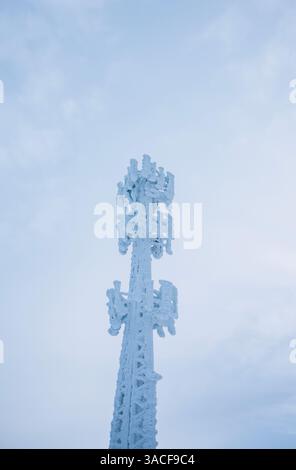 Eis- und schneebedeckter Funkturm im Winter in Maine Stockfoto