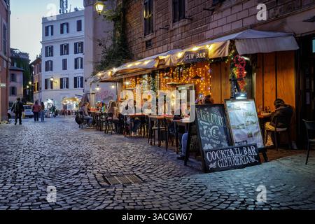 Rom, Italien - 31. März 2025: Abends in Trastevere, einem typischen Trattoria-Restaurant, das von Touristen in der Stadt besucht wird, mit Tischen und Stockfoto