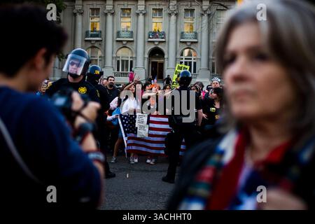 Februar 2008 - Berkeley, Kalifornien, USA - Anti-Kriegs-Demonstranten singen Lieder von einer pro-militärischen Menschenmenge in Berkeley, Kalifornien Eine Entscheidung des Stadtrates von Berkeley, auf die Anwesenheit des Rekrutierungsbüros des Marine Corps in seiner Stadt zu verzichten, löste eine weit verbreitete Debatte aus und zog Hunderte ins Rathaus von Berkeley, um zu erfahren, ob der rat seine Entscheidung widerrufen würde. Anti-Kriegs-Demonstranten reihten sich auf einer Seite von Martin Luther King Jr. an Way und pro-militärische Unterstützer auf der anderen. Beide Gruppen sangen Lieder, zündeten Musik aus Lautsprechern und verhöhnten sich gegenseitig, und mehrere Verhaftungen wurden durchgeführt. (C Stockfoto