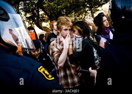 Februar 2008 - Berkeley, Kalifornien, USA - Anti-Kriegs-Anhänger sprechen hinter einer Polizeilinie in Berkeley, Kalifornien Eine Entscheidung des Stadtrates von Berkeley, auf die Anwesenheit des Rekrutierungsbüros des Marine Corps in seiner Stadt zu verzichten, löste eine weit verbreitete Debatte aus und zog Hunderte ins Rathaus von Berkeley, um zu erfahren, ob der rat seine Entscheidung widerrufen würde. Anti-Kriegs-Demonstranten reihten sich auf einer Seite von Martin Luther King Jr. an Way und pro-militärische Unterstützer auf der anderen. Beide Gruppen sangen Lieder, zündeten Musik aus Lautsprechern und verhöhnten sich gegenseitig, und mehrere Verhaftungen wurden durchgeführt. (Kreditbild: © Dave Getzschman/Z Stockfoto