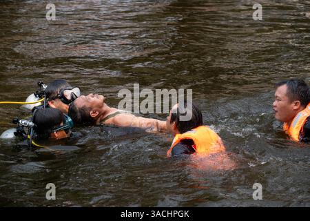 Chiang Mai, Thailand. April 2025. Katastrophenschutz- und Schadensbegrenzungsbeamte werden während einer Wasserrettung am Graben beobachtet, wie sie die Wasserrettung eines ertrinkenden Opfers üben. Die Gemeinde Chiang Mai führte Hochhaus- und Wasserrettungsübungen durch, um das Notfallpersonal auf mögliche Vorfälle während des Songkran Festivals und mögliche Erdbeben vorzubereiten. (Foto: Pongmanat Tasiri/SOPA Images/SIPA USA) Credit: SIPA USA/Alamy Live News Stockfoto