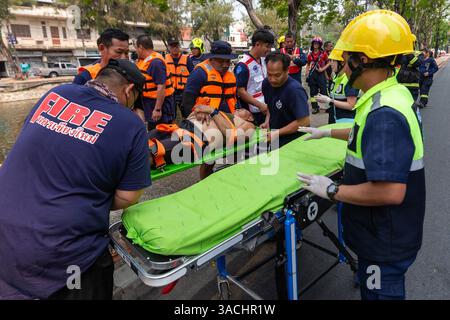 Chiang Mai, Thailand. April 2025. Katastrophenschutz- und Schadensbegrenzungsbeamte werden während einer Wasserrettung am Graben beobachtet, wie sie die Wasserrettung eines ertrinkenden Opfers üben. Die Gemeinde Chiang Mai führte Hochhaus- und Wasserrettungsübungen durch, um das Notfallpersonal auf mögliche Vorfälle während des Songkran Festivals und mögliche Erdbeben vorzubereiten. Quelle: SOPA Images Limited/Alamy Live News Stockfoto