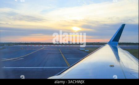 Blick auf Sonnenaufgang vom Flugzeugfenster am Flughafen. Stockfoto