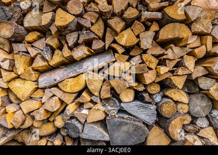 Gestapelte Holzstämme schaffen ein rustikales und natürliches Display, das perfekt für Holzlagerprojekte mit Brennholz oder für die Innenraumgestaltung geeignet ist, ein Symbol für Wärme und Nachhaltigkeit Stockfoto