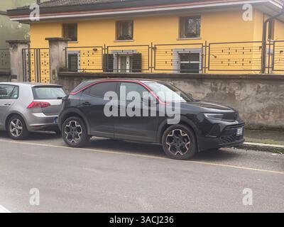 Crema, Italien - 2. März 2025 Moderne Opel Mokka GS-Linie mit markanter roter Zierleiste in der Nähe eines lebhaften gelben Wohngebäudes, das den sle unterstreicht Stockfoto