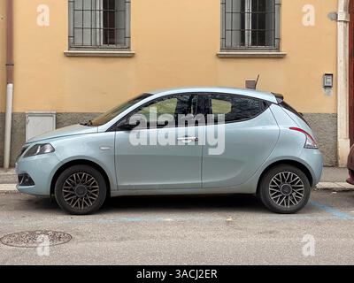 Crema, Italien - 2. März 2025 Hellblau Lancia Ypsilon 1,2 8v EcoChic 69 cv parkt neben einem lebhaften gelben Wohngebäude, das sich nahtlos verbindet Stockfoto