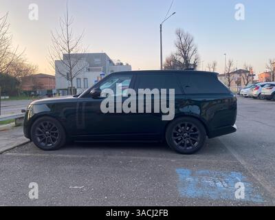 Crema, Italien - 2. März 2025 Grüner Range Rover mit langem Radstand, der bei Sonnenuntergang auf einem Parkplatz geparkt wurde, unterstreicht sein elegantes Design und die luxuriöse fea Stockfoto