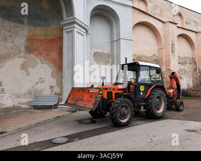Prag, Tschechische Republik - 26. März 2025: Roter zetor-Traktor parkt auf einer prager Straße vor einer verwitterten Mauer mit Bögen und verschmilzt das ländliche Leben Stockfoto