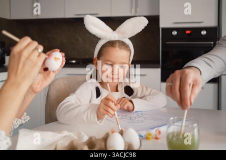 Die Familie dekoriert Ostereier zu Hause in festlicher Atmosphäre Stockfoto