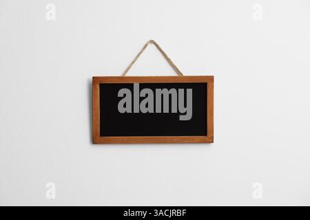 Eine leere kleine Tafel an der weißen Wand Stockfoto