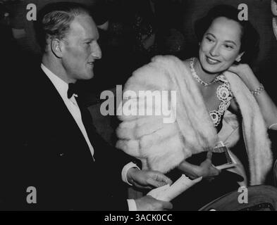 Foto zeigt:- heute Abend das Foto des grafen von Dalkeith und Merle Oberon im Theater. Earl and Film Star at First Night Tonight:- der Earl of Dalkeith ging heute Abend mit Filmstar Merle Oberon ins Westminster Theatre, um die erste Nacht des neuen Stücks „A Priest in the Family“ von John Synge und Kieran Tunney zu sehen. John Synge ist ein Enkel des berühmten irischen Dramatikers J.M.Synge und ein alter Freund des Earl of Dalkeith. Der Earl traf Merle Oberon kürzlich in Hollywood, wo er ihr Gast war. „Sie ist eine Freundin der Familie“, sagte er. 01. Oktober 1951. (Foto von Paul Popper) Stockfoto