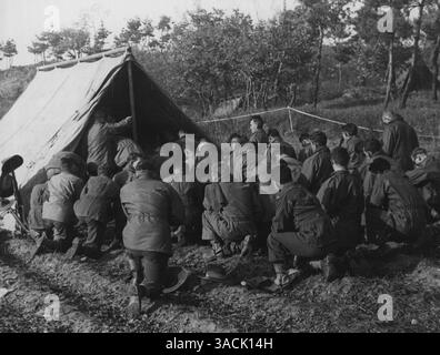 Abteilung für Öffentlichkeitsarbeit, Hauptquartier, BCOF, Japan - Männer des 3. Bataillons Royal Australian Regiment nehmen am 1. November an der Messe im BN HQ in der Nähe von Chongju, Korea Teil. Der Celebrant, Chaplin E. B. Phillips, ist im Zelt verdeckt. Juli 1950. Stockfoto