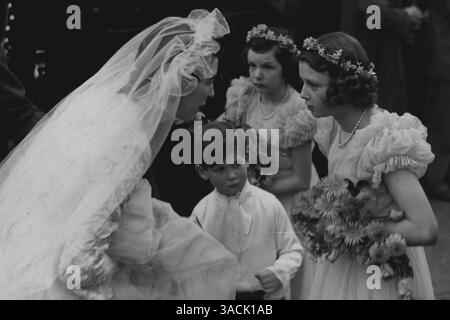 Königliche Gäste bei St. Margaret's Wedding. Das Bild zeigt:- nach ihrer Hochzeit hielt die Braut an, um mit ihren Brautbegleitern zu sprechen, als sie die Kirche verließ. Mitglieder der Königlichen Familie trugen heute Dienstag in St. Margaret's, Westminster, Tochter von Sir Harold und Lady Ziz Wernher aus Thorpe Lubenham, Hall Market Harborough, war mit Major David Butter, M.C., den Scots Guards, verheiratet. In Anwesenheit der Braut waren Prinzessin Alexandra von Kent und ihr kleiner Bruder, Prinz Michael. November 1946 Stockfoto