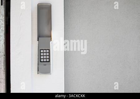 Tastatur für Garagentore oder schlüssellose Tür. Graue, wasserdichte Box, montiert an der Außenwand des Hauses oder Gebäudes. Wird für codierten Zugriff auf Open d verwendet Stockfoto