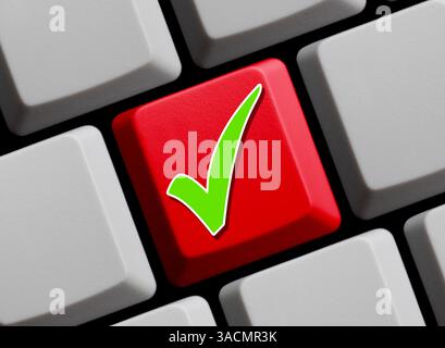 Grünes Häkchen auf der roten Computertastatur Stockfoto