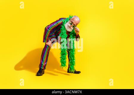 Foto des charismatischen älteren Mannes tragen stilvolle gestreifte lebendige Kleidung Cool Party Event isoliert auf gelbem Hintergrund Stockfoto