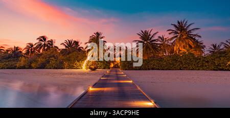 Fantastisches Panorama bei Sonnenuntergang auf den Malediven. Luxuriöses Resort Pier Path Seascape mit sanften LED-Lichtern und farbenfrohem Himmel. Wunderschöner Abendhimmel und farbenfrohe Wolken Stockfoto