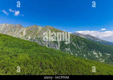 Am frühen Morgen in der Hohen Tatra, Slowakei. Ein fantastischer Blick auf hohe felsige Gipfel, umgeben von Wolken während der goldenen Stunde. Sonnenaufgang über der Hohen Tatra Stockfoto
