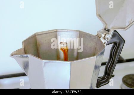 Nahaufnahme einer neapolitanischen Kaffeemaschine, die Espresso auf einem Herd zubrüht und den Moment der Extraktion festnimmt Stockfoto