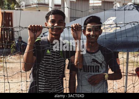 Kampot, Kambodscha 07. Mai 2018. Ein Fußballturnier in Kampot. Khmer-Fußballfans stehen hinter dem Netz und beobachten das Spiel in der Nachmittagssonne Stockfoto