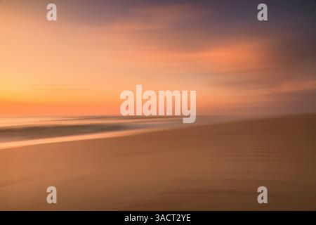 Farbenfroher Sonnenuntergang am Meer, aufgenommen mit absichtlicher Kamerabewegung (ICM) Stockfoto