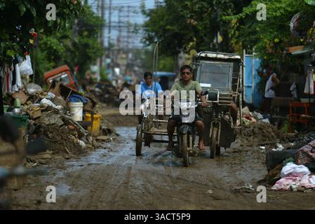 27. Dezember 2011 - Cagayan de Oro, Philippinen - zwei Wochen nach der Überschwemmung werden immer noch Trümmerhaufen und Schlammhaufen auf den Straßen zurückgelassen. Ein ganzes Dorf entlang des Flusses in Cagayan de Oro City, im Süden der Philippinen, wurde von der Sturzflut am Vorabend des 16. Dezember 2011 bis zum Morgengrauen wegen des Tropensturms Washi weggespült. Zwei Wochen später stieg die Zahl der Todesopfer auf 1.257 an, während schätzungsweise mehr als tausend vermisst werden, was es zur schlimmsten Katastrophe macht, die die Philippinen im letzten Jahr getroffen hat. (Bild: © Keith Bacongco/ZUMAPRESS.com) Stockfoto