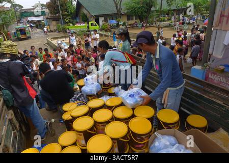 27. Dezember 2011 - Cagayan de Oro, Philippinen - Opfer erhalten weiterhin Nahrungsmittelhilfe im Evakuierungszentrum in Cagayan de Oro City, Südphilippinen. Zwei Wochen nach der Sturzflut durch den Tropensturm Washi muss die Stadt das Wassersystem erst wieder herstellen, nachdem es durch die Sturzflut beschädigt wurde. 80 Prozent der Stadt leiden immer noch unter Wasserknappheit. (Bild: © Keith Bacongco/ZUMAPRESS.com) Stockfoto