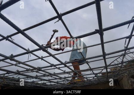 27. Dezember 2011 - Cagayan de Oro, Philippinen - Ein philippinischer Überschwemmungsopfer hämmert an der Wand seines zerstörten Hauses Hämmer, um die Stahlstäbe zu retten und sie für Geld an Schrottläden zu verkaufen. Ein ganzes Dorf entlang des Flusses in Cagayan de Oro City, im Süden der Philippinen, wurde von der Sturzflut am Vorabend des 16. Dezember 2011 bis zum Morgengrauen wegen des Tropensturms Washi weggespült. Zwei Wochen später stieg die Zahl der Todesopfer auf 1.257 an, während schätzungsweise mehr als tausend vermisst werden, was es zur schlimmsten Katastrophe macht, die die Philippinen im letzten Jahr getroffen hat. (Bild: © Keith Bacongco/ZUMAPRESS.com) Stockfoto