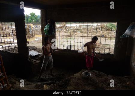 27. Dezember 2011 - Cagayan de Oro, Philippinen - Flutopfer entfernen Schlamm aus ihrem Haus in Cagayan de Oro City, Südphilippinen zwei Wochen nach der verheerenden Sturzflut. Das gesamte Dorf entlang des Flusses in Cagayan de Oro City, im Süden der Philippinen, wurde am Vorabend des 16. Dezember 2011 durch die Sturzflut bis zum Morgen des nächsten Tages durch den Tropensturm Washi weggespült. Zwei Wochen später stieg die Zahl der Todesopfer auf 1.257 an, während schätzungsweise mehr als tausend vermisst werden, was es zur schlimmsten Katastrophe macht, die die Philippinen im letzten Jahr getroffen hat. (Bild: © Keith Bacongco/ZUMAPRESS Stockfoto