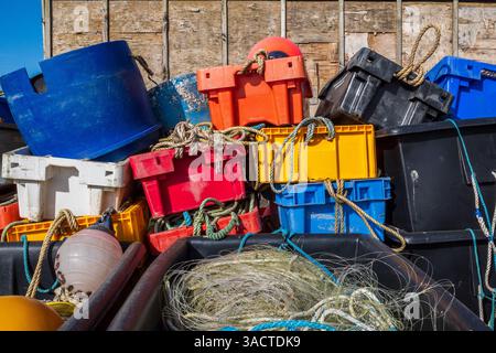 Bunte Fischkisten, Töpfe, Netze und Seile an einem britischen Kai. Farbenfrohe Abstraktion, Hintergrund, Konzept. Britische Fischereiindustrie. Stockfoto