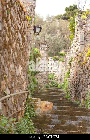 Steintreppen zwischen mittelalterlichen Mauern von Häusern in der Bucht von Porto Venere, Ligurien. Tourismus in Italien. Traditionelle Gebäude. Hintergrund für die Konstruktion. Stockfoto