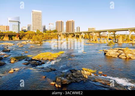 Blick von der T. Tyler Potterfield Memorial Bridge (Brown's Island Dam Walk) im James River Park über den James River bis zur Skyline der Innenstadt von Richmond und der Mayo Bridge in Richmond, Virginia, USA Stockfoto