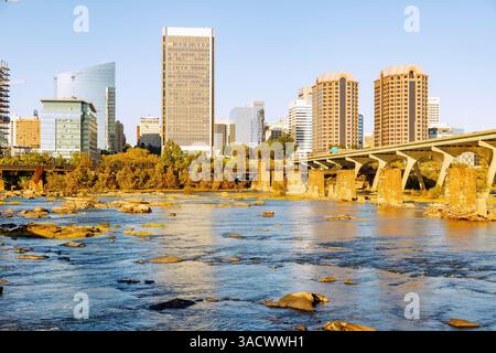 Blick von der T. Tyler Potterfield Memorial Bridge (Brown's Island Dam Walk) im James River Park über den James River bis zur Skyline der Innenstadt von Richmond und der Mayo Bridge in Richmond, Virginia, USA Stockfoto