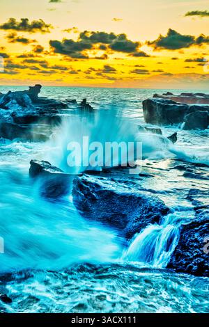 Wellen, die vom Indischen Ozean an der Lava-Küste in Munggu Beach, Bali Indonesien, explodieren Stockfoto