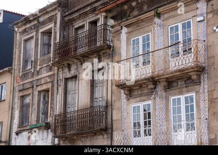 Ein altes Ruinen- und verlassenes Haus neben einem renovierten Wohnhaus irgendwo in Braga, Portugal Stockfoto