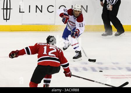 Februar 2012 - Newark, New Jersey, Vereinigte Staaten von Amerika - Montreal Canadiens Center Scott Gomez (11) passiert den Puck am linken Flügel der New Jersey Devils Alexei Ponikarovsky (12) während der 2. Periode des NHL-Spiels zwischen den Montreal Canadiens und den New Jersey Devils im Prudential Center in Newark, NJ (Credit Image: © Vinny Carchietta/Southcreek/ZUMAPRESS.com) Stockfoto