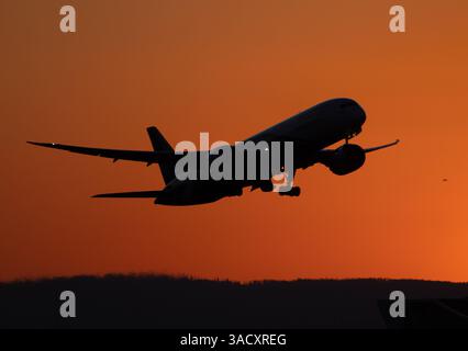 04. April 2025, Hessen, Frankfurt/Main: Ein Passagierflugzeug startet im letzten Abendlicht am Frankfurter Flughafen. Foto: Boris Roessler/dpa Stockfoto