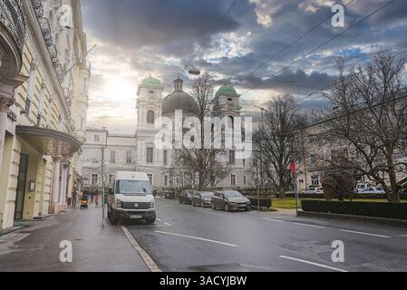 Straßenszene in Salzburg mit der Dreifaltigkeitskirche Stockfoto