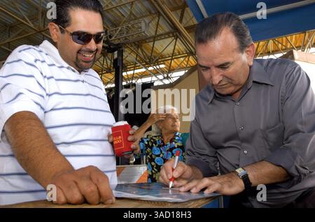 13. Mai 2006 – San Antonio, Texas, USA – Conjunto-Superstar Angel Flores, rechts, unterzeichnet am Sonntag, den 14. Mai 2006, beim 25. Jährlichen Tejano Conjunto Music Festival in San Antonio, Texas, Autogramme für seine Fans. Conjunto-Musik begann vor mehr als 100 Jahren, als die indigene mexikanische Bevölkerung in Südtexas das lebhafte Dreiknopf-Akkordeon deutscher Siedler übernahm und es mit der spanischen 12-saitigen Bassgitarre Bajo sexto kombinierte. Conjunto-Musiker mischten europäische Rhythmen wie Polkas und Walzer mit indigenen mexikanischen Musikformen. Der Conjunto-Sound wurde von Americ beeinflusst Stockfoto