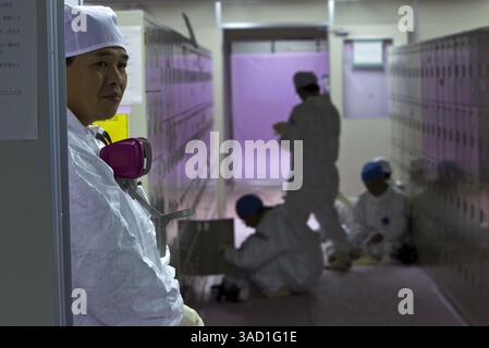 12. November 2011 - Tokio, Japan - Arbeiter in Schutzanzügen versammeln sich am Samstag, 12. November 2011 in der Noteinsatzzentrale des zerstörten Kernkraftwerks Fukushima Dai-ichi in Okuma, Japan. Die Medien, die zum ersten Mal in Japans durch Tsunami geschädigtes Kernkraftwerk eingelassen haben, erlebten Samstag eine beeindruckende Szene der Verwüstung: Verdrehte und umgekippte Fahrzeuge, zerbröckelnde Reaktorgebäude und Schutthaufen, die seit der Welle vor mehr als acht Monaten praktisch unberührt blieben. (Kreditbild: © David Guttenfelder-Pool/Jana Press/ZUMAPRESS.com) Stockfoto