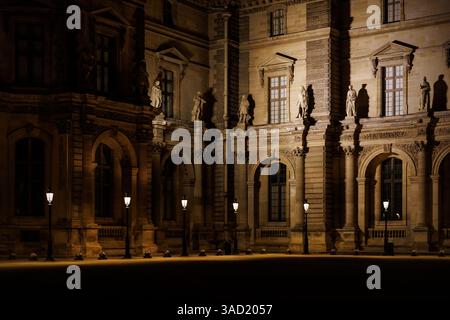 Ein großes Gebäude mit vielen Fenstern und einem Innenhof. Der Innenhof ist von mehreren Lichtern beleuchtet Stockfoto