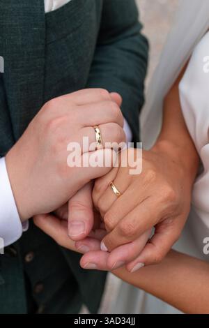 Braut und Bräutigam halten Hände, zeigen ihre Eheringe Stockfoto
