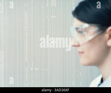 Laborassistent trägt eine Schutzbrille vor DNA-Codes Stockfoto