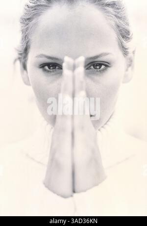 Young woman holding hands in front of her face Stockfoto