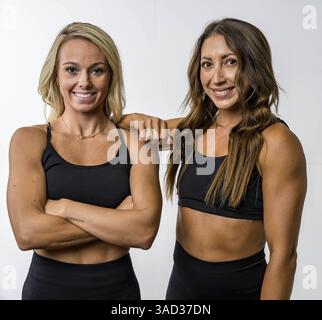 Zwei attraktive Modelle mit sportlicher Passform posieren selbstbewusst, ihre kräftigen Muskeln werden durch sanftes Licht hervorgehoben. Sie strahlen Kraft und Anmut aus und zeigen ihre en Stockfoto