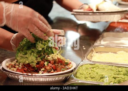 4. Dezember 2015 - Datei - der E. coli-Ausbruch in Verbindung mit Chipotle Mexican Grill Inc. Hat sich auf neun US-bundesstaaten ausgeweitet, sagten die Behörden am Freitag, und die Burrito-Kette sagte, ihre Verkäufe seien geschädigt worden, da sie eine Warnung für das vierte Quartal ausgab. Abbildung: 28. September 2011 - Chicago, IL, USA - die letzten Details werden einem Burrito Bowl in einem Chipotle Restaurant hinzugefügt. Die Kette fördert die Verwendung nachhaltiger Erzeugnisse und ethisch behandelter Tiere. (Bild: © Michael Tercha/Chicago Tribune/TNS/ZUMAPRESS.com) Stockfoto